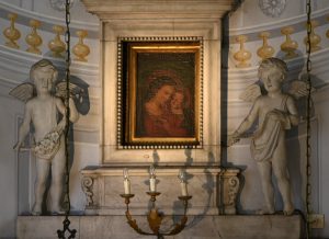 All’interno della cornice la piccola tela raffigurante la Madonna col Bambino secondo l’iconografia della Madonna del Buon Consiglio venerata nel santurio di Genazzano. Il quadro è opera del pittore pontremolese Pietro Pedroni che, verso la fine del XVIII secolo, la donò alla parrocchia di San Nicolò dove si trova, collocato in alto, sopra l’immagine del Cristo Nero.