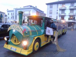 Pontremoli, piazza Italia. Il trenino llillupuziano con a bordo una viaggiatrice d’eccezione... la Befana