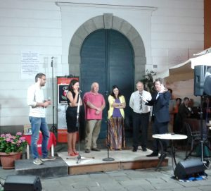 Il momento della premiazione: da sinistra Giacomo Pinelli, direttore artistico della manifestazione, Melania Leoncini in rappresentanza di Cristina Laporini, il vincitore della rassegna Gianluca Salinas e la seconda classificata Valentina Zinzula. Poi Roberto Bresciani ed il presentatore della serata Francesco Busani