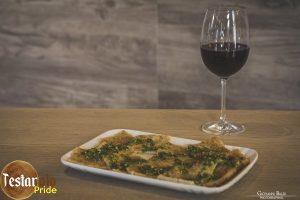 Un testarolo con il classico condimento al pesto.