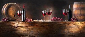 Bicchieri di vino rosso con botti e trave