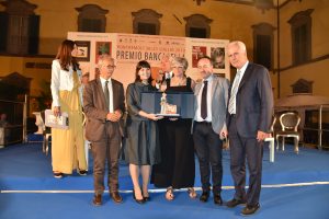 Il momento della premiazione di Alessia Gazzola. Sul palco con lei da sinistra, la presentatrice Gioia Marzocchi, l'onorevole Cosimo Ferri, il presidente della fondazione "Città del Libro" Gianni Tarantola, il sindaco di Pontremoli Lucia Baracchini, il segretario del Premio Ignazio Landi e il presidente del consiglio regionale Eugenio Giani.