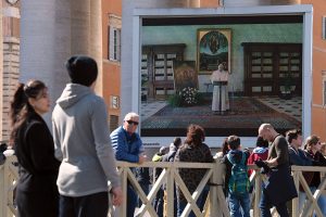 Fedeli in piazza San Pietro davanti ai maxi schermi