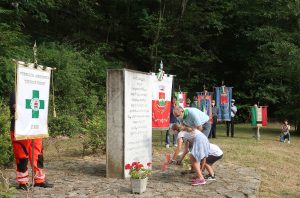 Il momento della deposizione di fiori di fronte al monumento in ricordo di Facio ad Adelano di Zeri (foto Walter Massari)