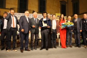 a consegna del San Giovannino di Dio a Trellini con sul palco tutti protagonisti della serata. A fianco,