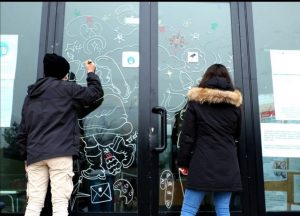 Gli studenti del Belmesseri impegnati a decorare le vetrine di alcuni esercizi commerciali di Villafranca