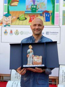 Lo scrittore Giuseppe Festa con la statuetta del San Giovanni di Dio, simbolo della vittoria del Premio Bancarellino